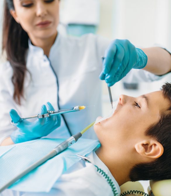 Injection of anesthesia, boy in dental chair